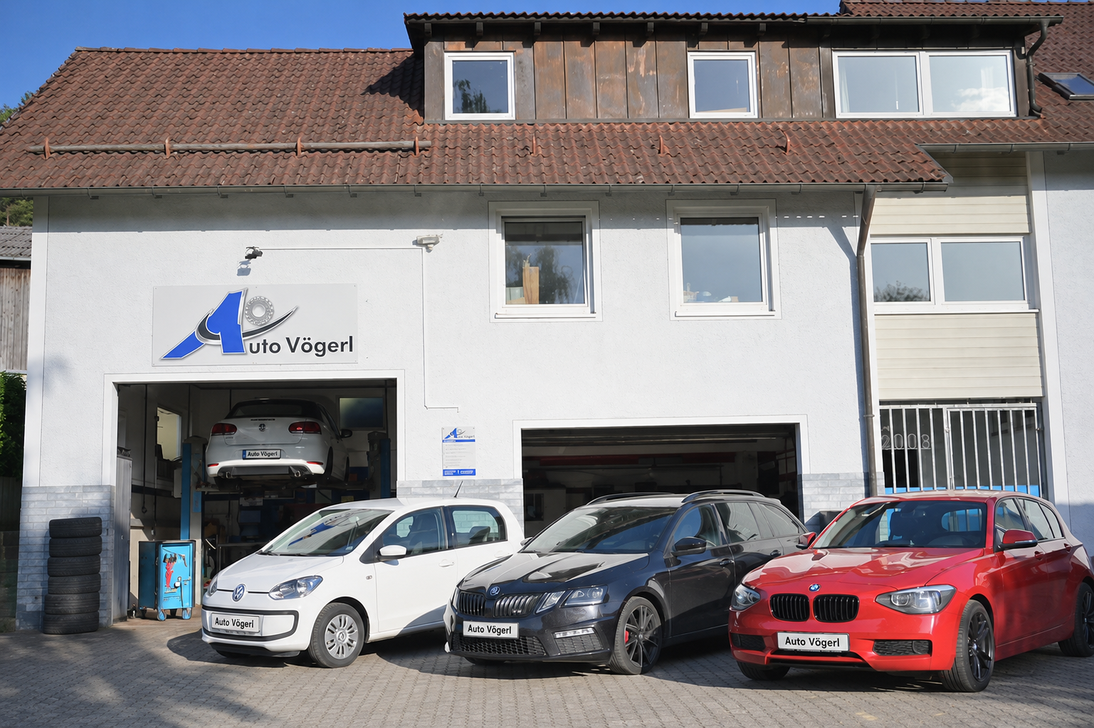 Werkstattgebäude von Auto Vögerl in Dantersdorf bei Velburg mit Fahrzeugen vor den Hallentoren